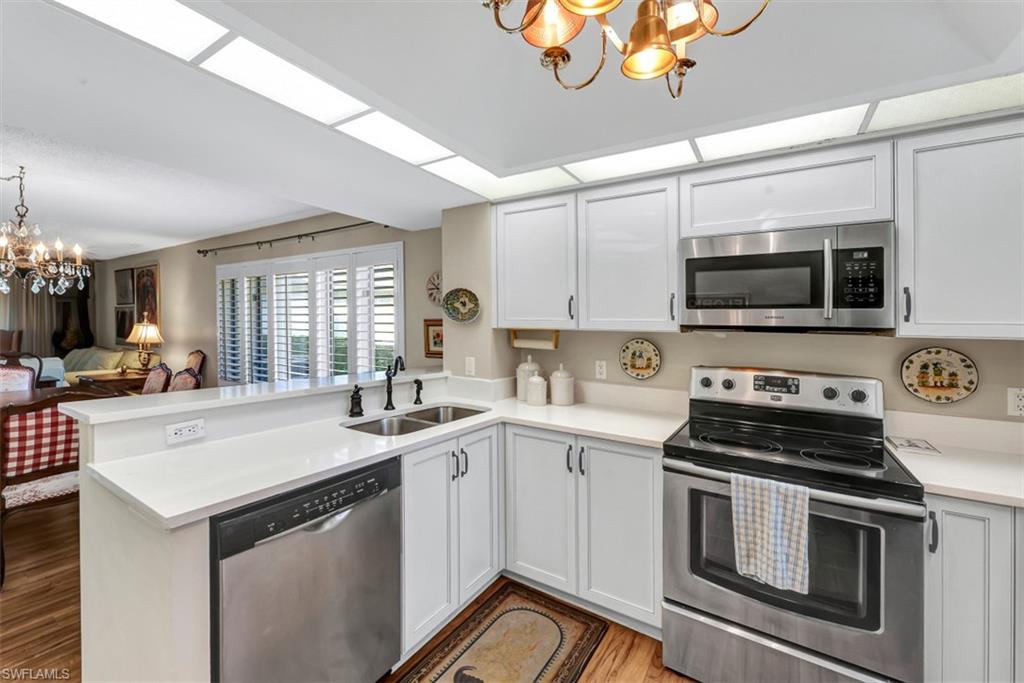 1617 Spoonbill Lane, Unit 1617 Naples, FL 34105 - Photo 6 of 31 a kitchen with a sink stove and microwave