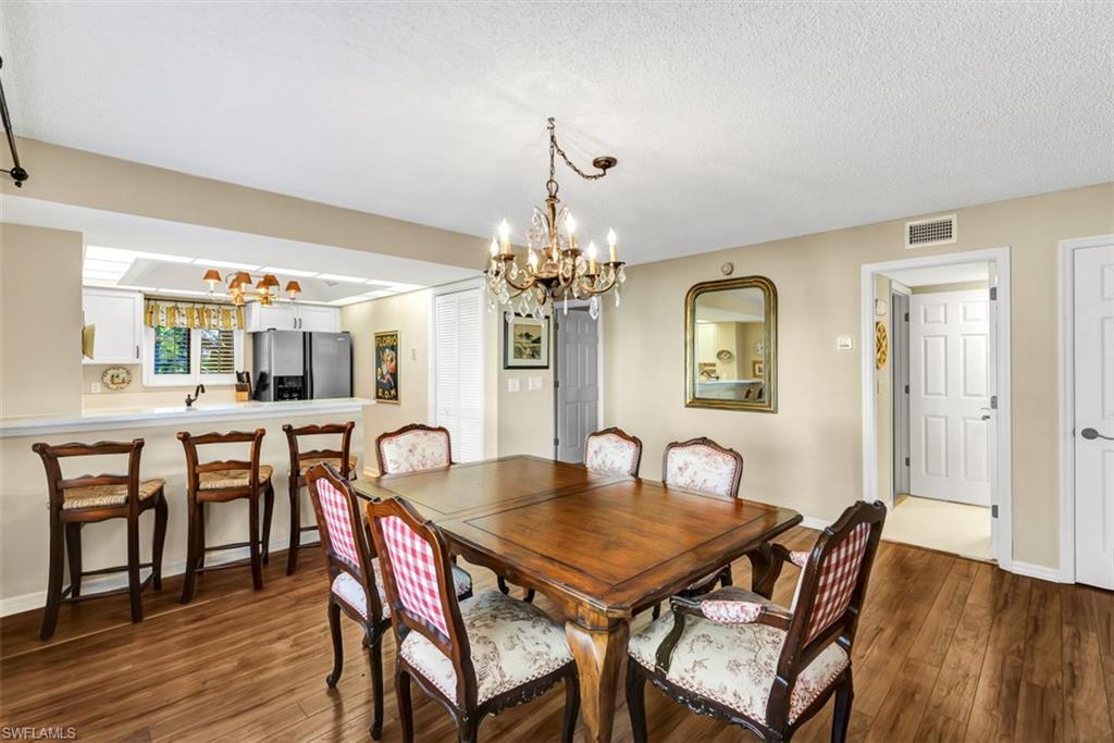 1617 Spoonbill Lane, Unit 1617 Naples, FL 34105 - Photo 7 of 31 a view of a dining room with furniture and wooden floor