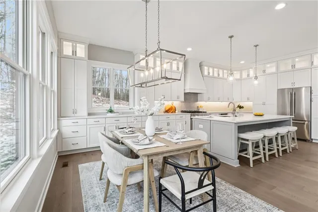a kitchen with a dining table chairs and large windows