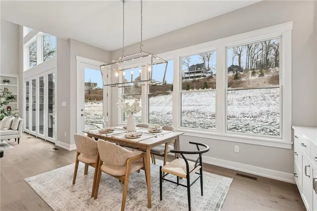 a dining room with furniture a chandelier and wooden floor