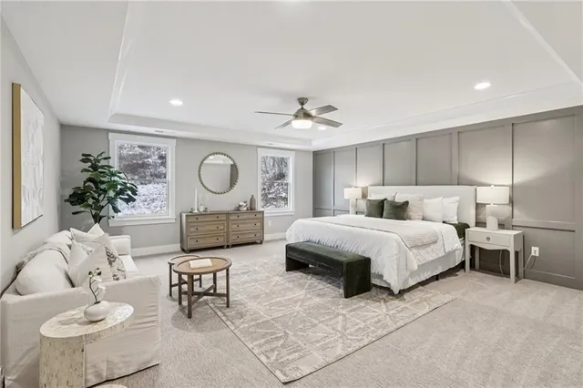 a spacious bedroom with a bed a couch and a potted plant