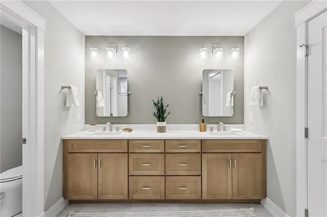 a bathroom with a double vanity sink mirror and toilet