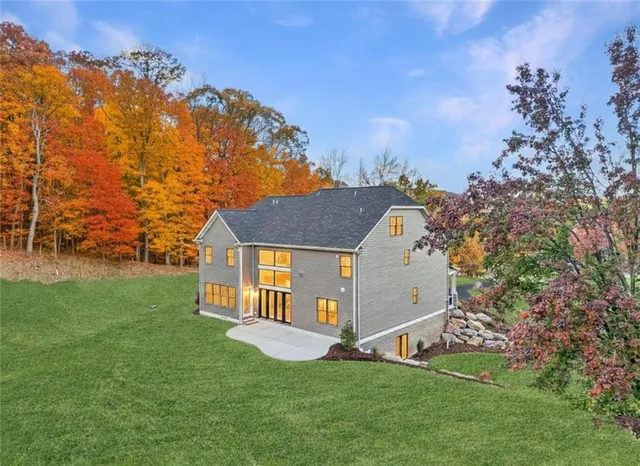 a front view of a house with a yard and trees