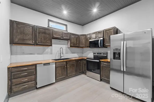 a kitchen with granite countertop stainless steel appliances and wooden cabinets