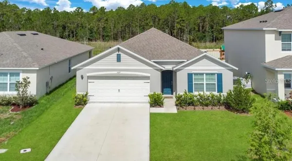a house with green field in front of it