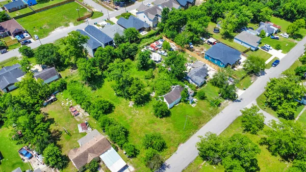 an aerial view of residential houses with outdoor space and street view