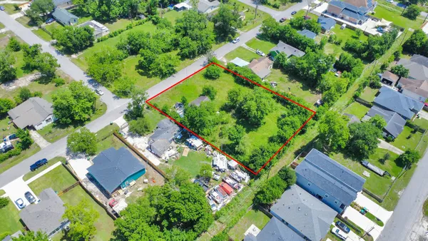 an aerial view of a house with a yard and lake view
