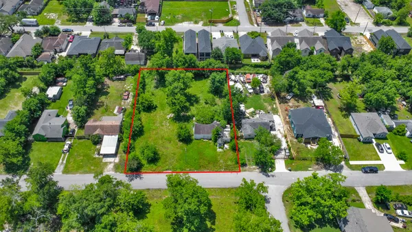 an aerial view of residential houses with outdoor space and trees