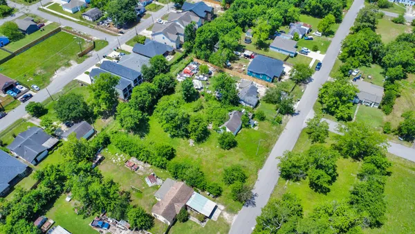 an aerial view of residential houses with outdoor space and street view