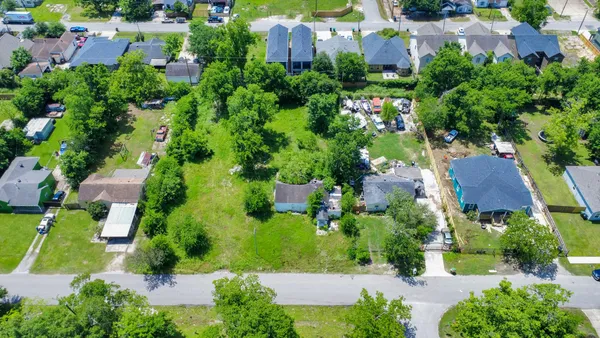 an aerial view of residential house with outdoor space and trees all around