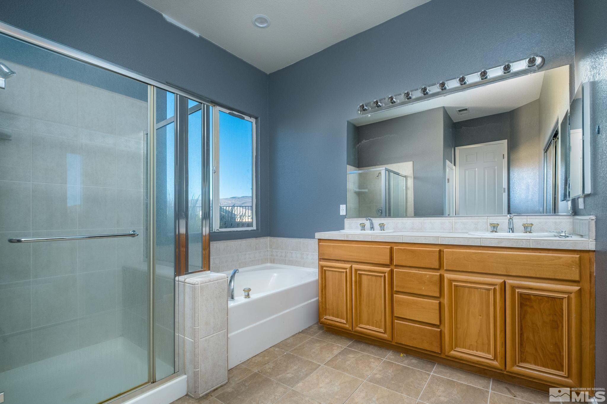1831 Emerald Bay Drive Reno, NV 89521 - Photo 23 of 34 a bathroom with a tub a double vanity sink and mirror