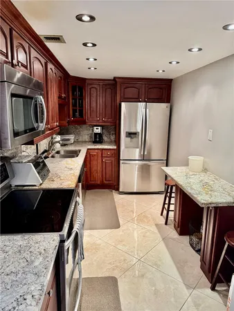 a bathroom with a granite countertop sink a toilet and a mirror