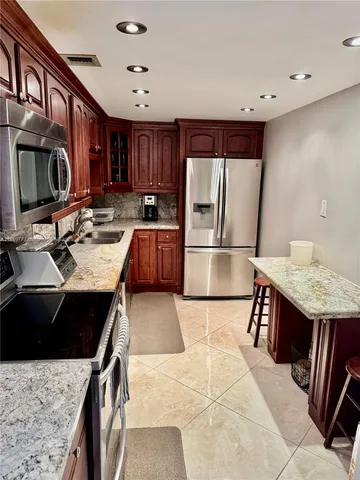 a bathroom with a granite countertop sink a toilet and a mirror