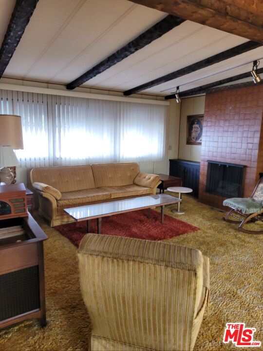 17700 South Avalon Boulevard, Unit 153 Carson, CA 90746 - Photo 16 of 17 a living room with furniture a fireplace and a table