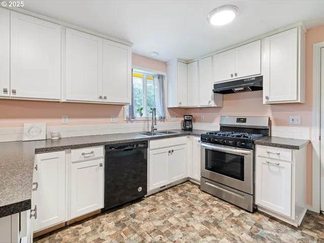 a kitchen with granite countertop white cabinets and white appliances