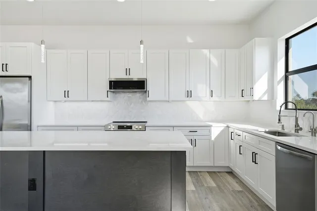a kitchen with a sink dishwasher a stove and a refrigerator
