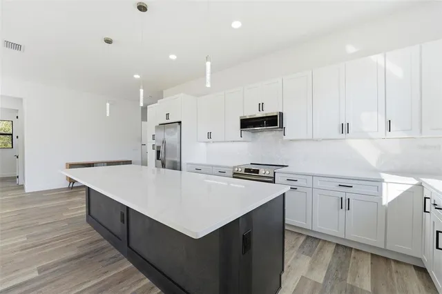 a kitchen with kitchen island a sink stove and wooden cabinets