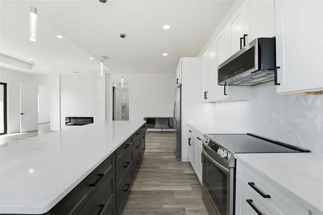 a kitchen with stainless steel appliances a sink and a refrigerator