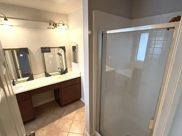 a bathroom with a double vanity sink mirror and shower