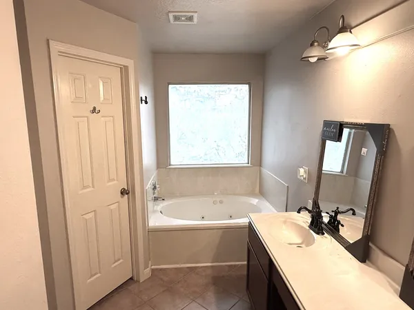 a bathroom with a tub sink and mirror