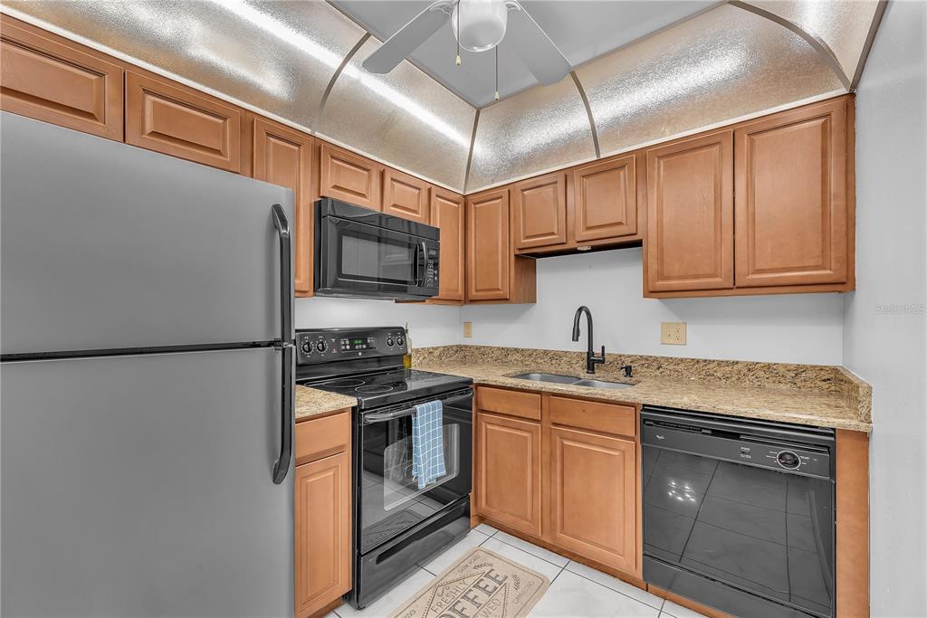 801 Russell Lane, Unit 255 Brandon, FL 33510 - Photo 10 of 22 a kitchen with stainless steel appliances granite countertop a refrigerator sink stove and microwave