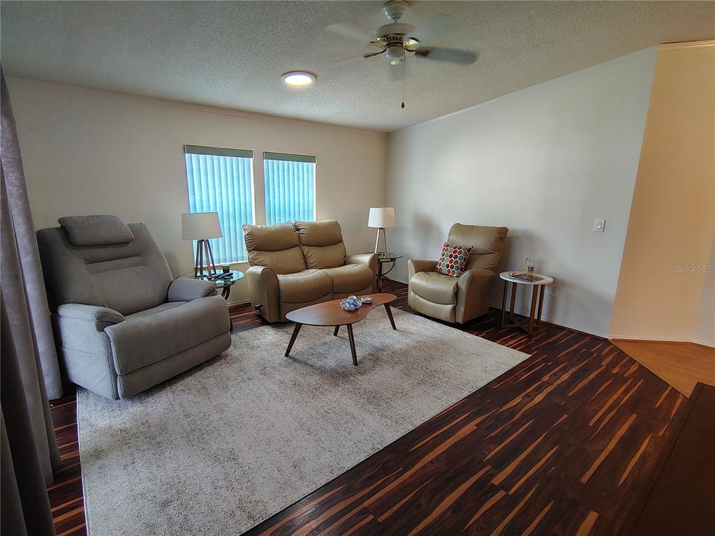 116 Lyonia Lane Wildwood, FL 34785 - Photo 6 of 37 a living room with furniture and a ceiling fan