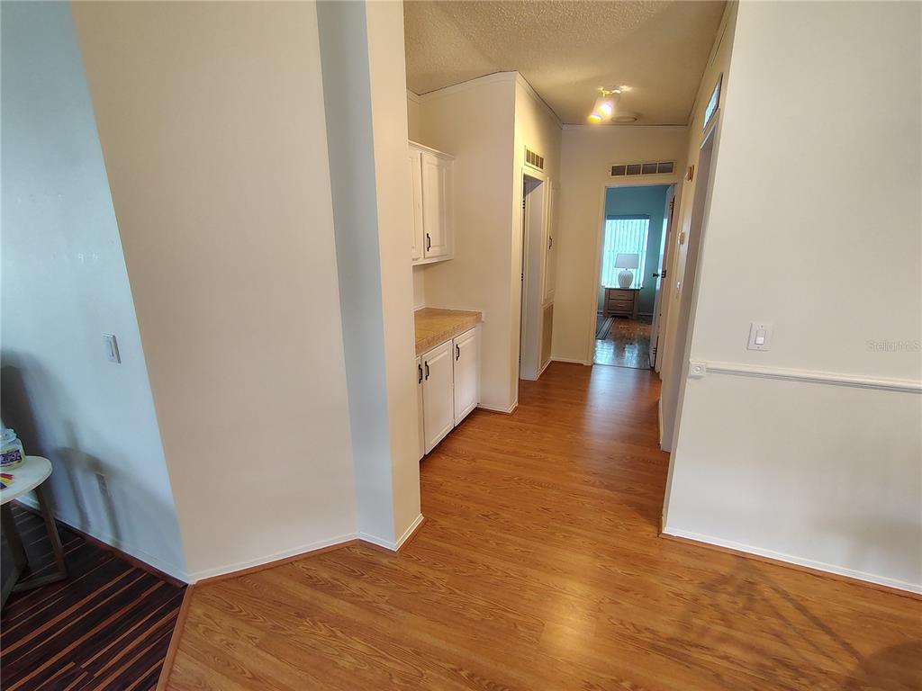 116 Lyonia Lane Wildwood, FL 34785 - Photo 10 of 37 a view of a hallway with wooden floor and staircase