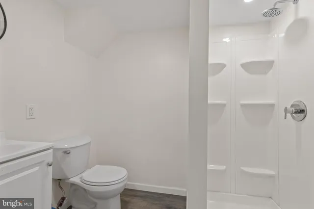 a white toilet sitting next to a shower