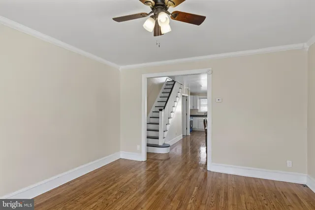 an empty room with wooden floor closet and windows
