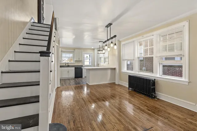 a view of a living room with wooden floor and windows