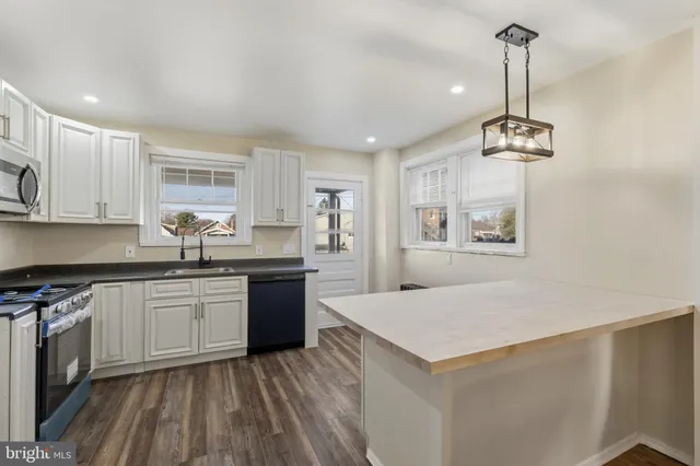 a kitchen with a refrigerator and white cabinets