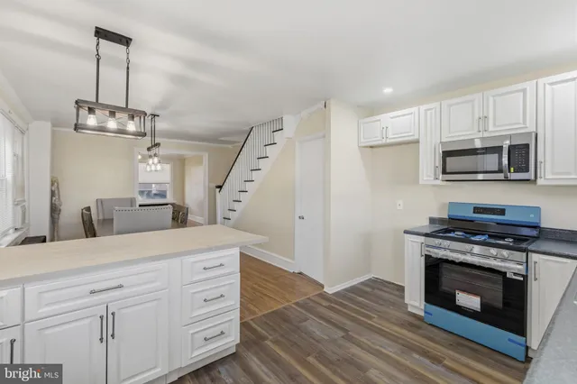 a kitchen with stainless steel appliances granite countertop a stove a sink and a refrigerator