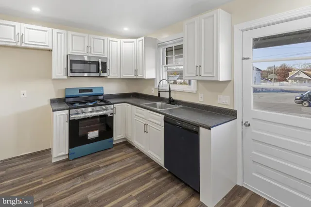 a kitchen with white cabinets and appliances