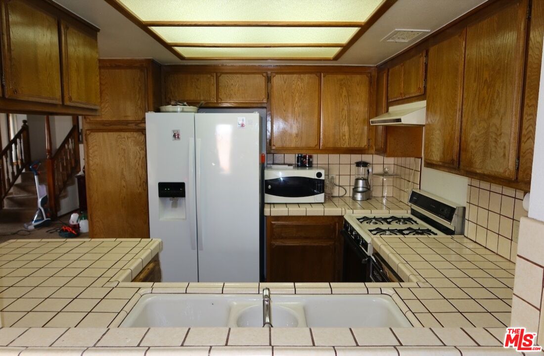 13330 Tamarisk Road Victorville, CA 92395 - Photo 18 of 33 a kitchen with stainless steel appliances a refrigerator and a stove