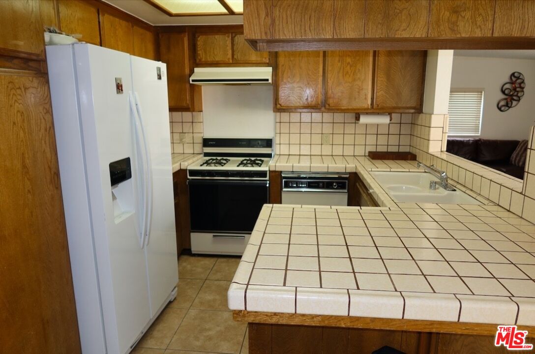 13330 Tamarisk Road Victorville, CA 92395 - Photo 19 of 33 a kitchen with a refrigerator and a stove