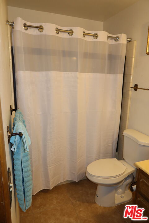 13330 Tamarisk Road Victorville, CA 92395 - Photo 29 of 33 a white toilet sitting next to a shower curtain