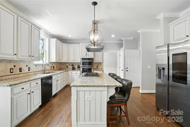 a kitchen with stainless steel appliances granite countertop a stove refrigerator and cabinets