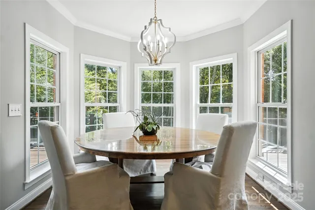 a view of a dining room with furniture a chandelier and wooden floor