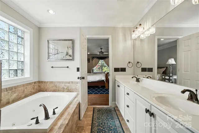 a spacious bathroom with a tub sink and mirror