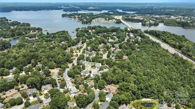 an aerial view of residential houses with outdoor space and trees