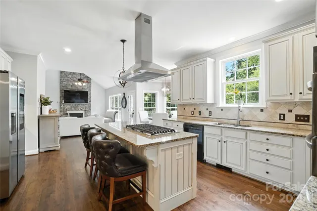 a kitchen with granite countertop a sink a counter space appliances and cabinets