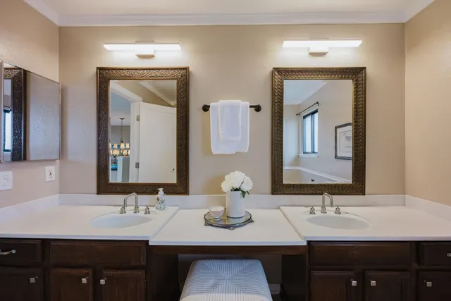 a bathroom with double vanity sinks and a mirror