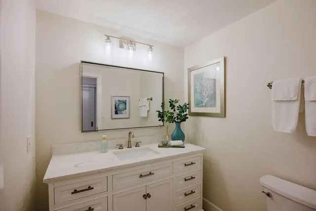 a bathroom with a granite countertop sink and a mirror