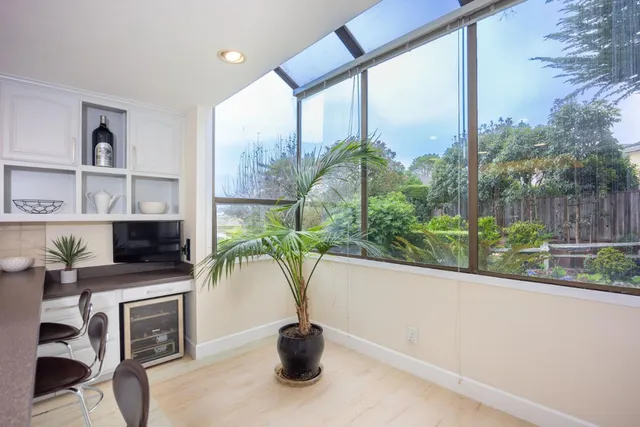 a white vase with flowers and a table