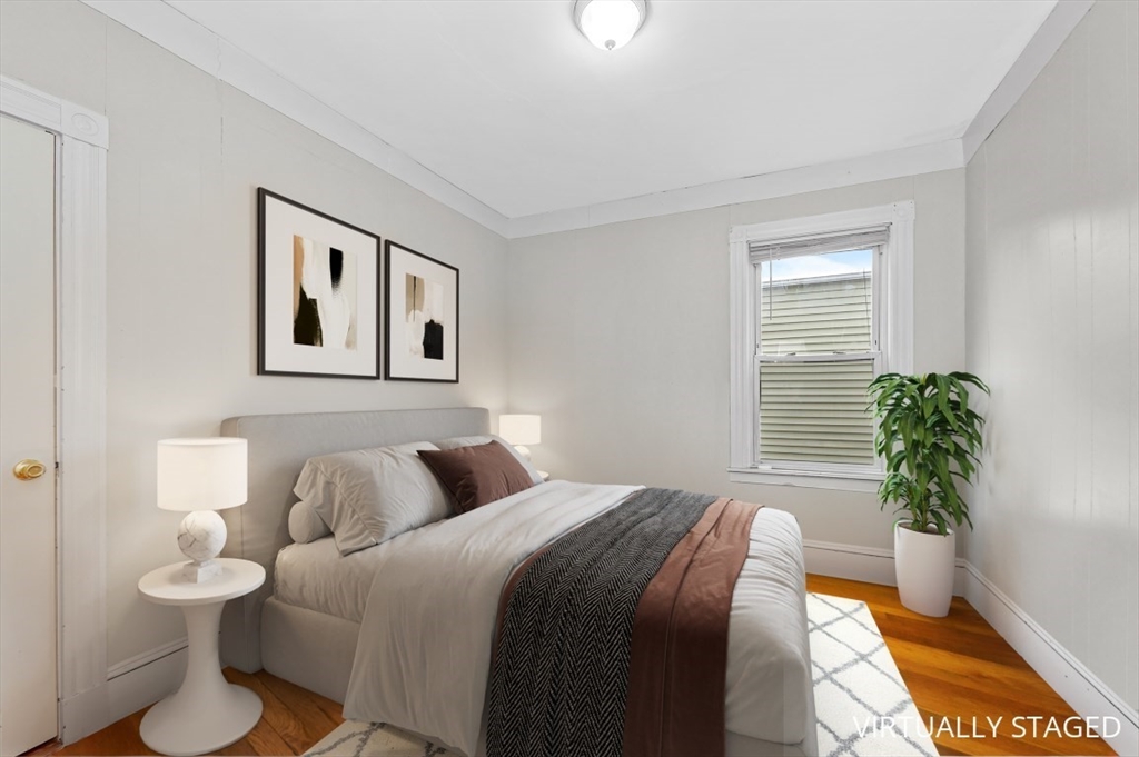 19 Dewolf Street Boston, MA 02125 - Photo 11 of 30 a bedroom with bed and a potted plant