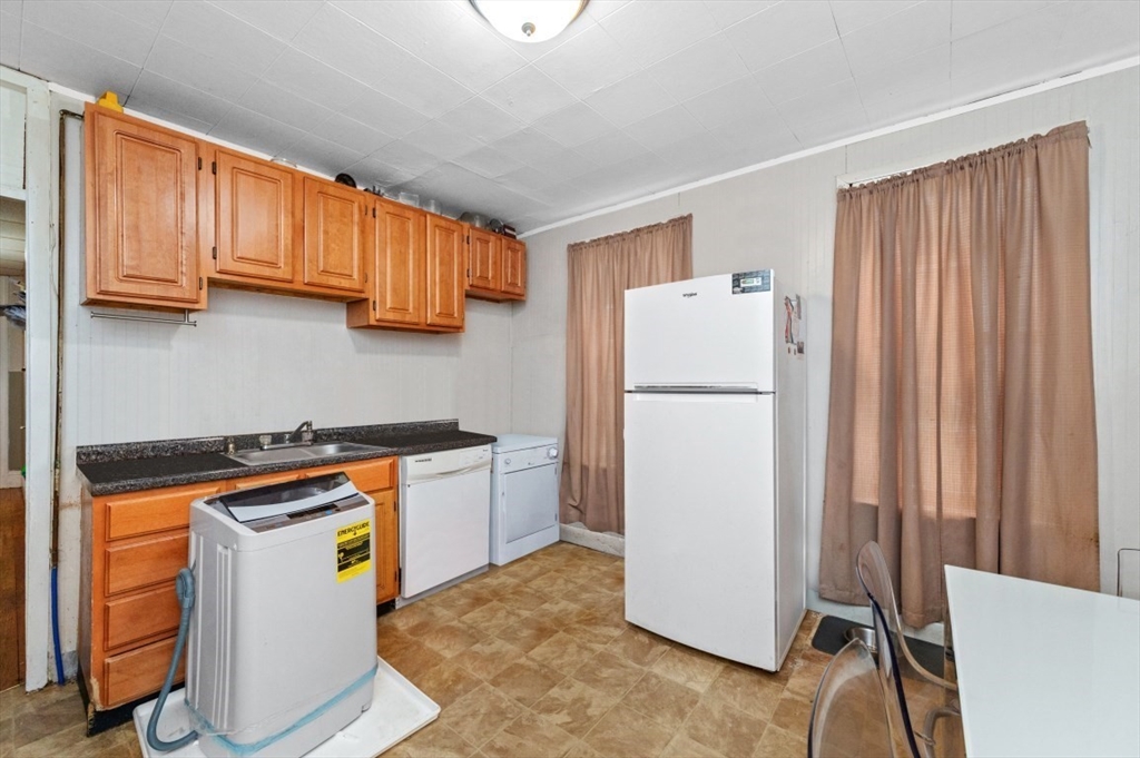 19 Dewolf Street Boston, MA 02125 - Photo 18 of 30 a kitchen with a refrigerator and a stove top oven