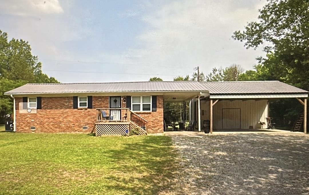 1245 Burnett Mills Road Bolivar, TN 38008 - Photo 1 of 1 Ranch-style home with crawl space, a carport, a metal roof, a front yard, and brick siding