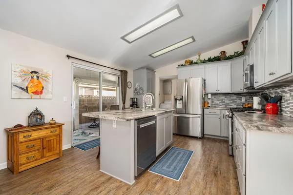 a kitchen with stainless steel appliances granite countertop a stove and a refrigerator