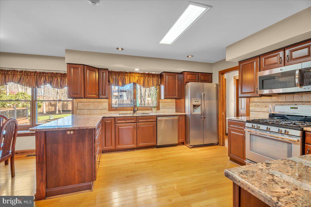 6 Edelweiss Lane Voorhees, NJ 08043 - Photo 8 of 46 a kitchen with stainless steel appliances granite countertop a stove top oven a sink dishwasher a refrigerator and cabinets with wooden floor