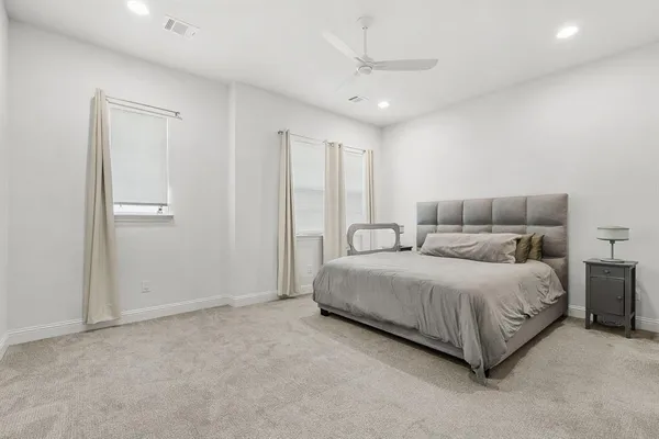 a spacious bedroom with a bed and a chandelier